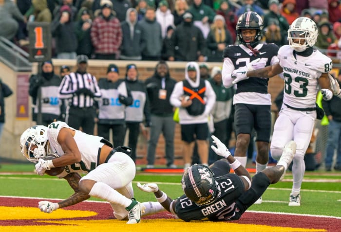 Oct 28, 2023; Minneapolis, Minnesota, USA; Michigan State Spartans wide receiver Tyrell Henry (2) scores a touchdown as Minnesota Golden Gophers defensive back Darius Green (12) defends during the fourth quarter at Huntington Bank Stadium.